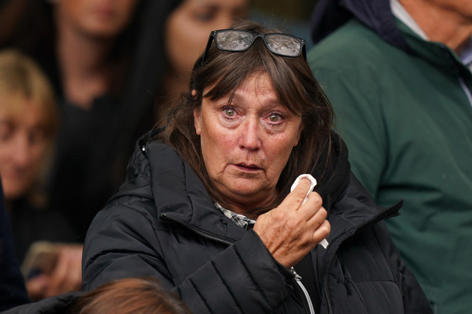 LONDON, ENGLAND - SEPTEMBER 19: A tearful mourner wipes their eyes during the State Funeral of Queen Elizabeth II on September 19, 2022 in London, England. Elizabeth Alexandra Mary Windsor was born in Bruton Street, Mayfair, London on 21 April 1926. She married Prince Philip in 1947 and ascended the throne of the United Kingdom and Commonwealth on 6 February 1952 after the death of her Father, King George VI. Queen Elizabeth II died at Balmoral Castle in Scotland on September 8, 2022, and is succeeded by her eldest son, King Charles III.  (Photo by Peter Summers/Getty Images)
