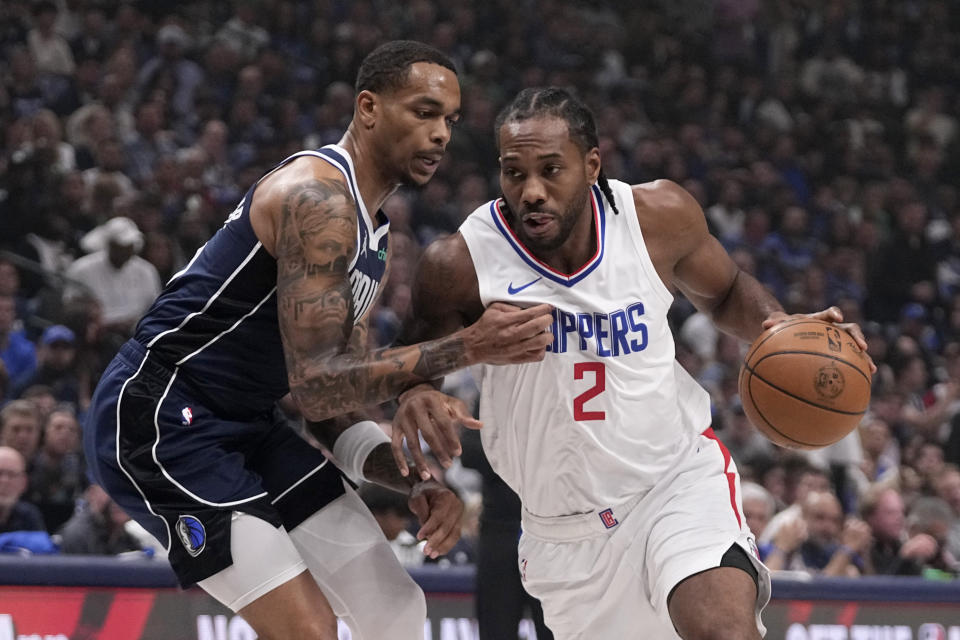 Dallas Mavericks forward P.J. Washington, left, defends as Los Angeles Clippers' Kawhi Leonard (2) works to the basket during the first half of Game 2 of an NBA basketball first-round playoff series Friday, April 26, 2024, in Dallas. (AP Photo/Tony Gutierrez)