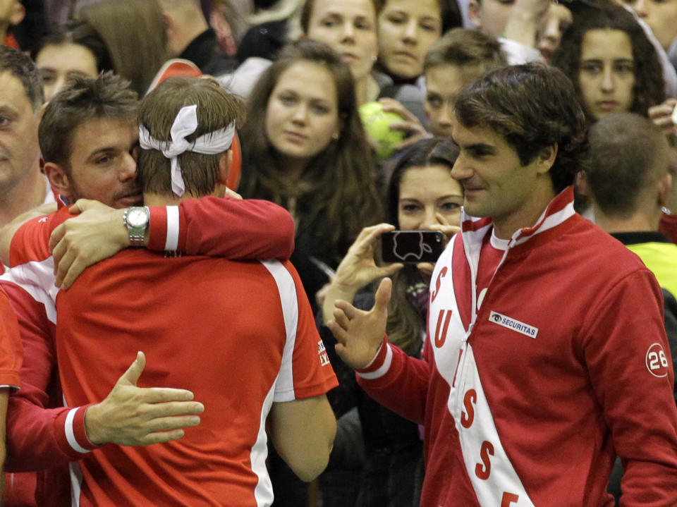 Switzerland's Michael Lammer, center, celebrates with Stanislas Wawrinka, left and Roger Federer after winning their Davis Cup World Group play-off first round doubles tennis match against Nenad Zimonjic and Filip Krajinovic of Serbia, in Novi Sad, Serbia, Saturday, Feb. 1, 2014. Chiudinelli and Lammer won the match and gave Switzerland a 2-1 lead. (AP Photo/Darko Vojinovic)