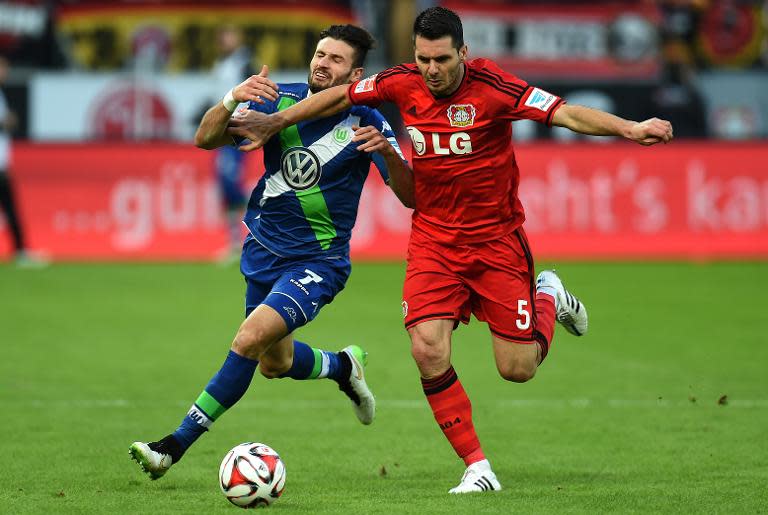 Wolfsburg's midfielder Daniel Caligiuri (L) and Leverkusen's Bosnian defender Emir Spahic vie for the ball during their German first division Bundesliga football match in Leverkusen, Germany on February 14, 2015