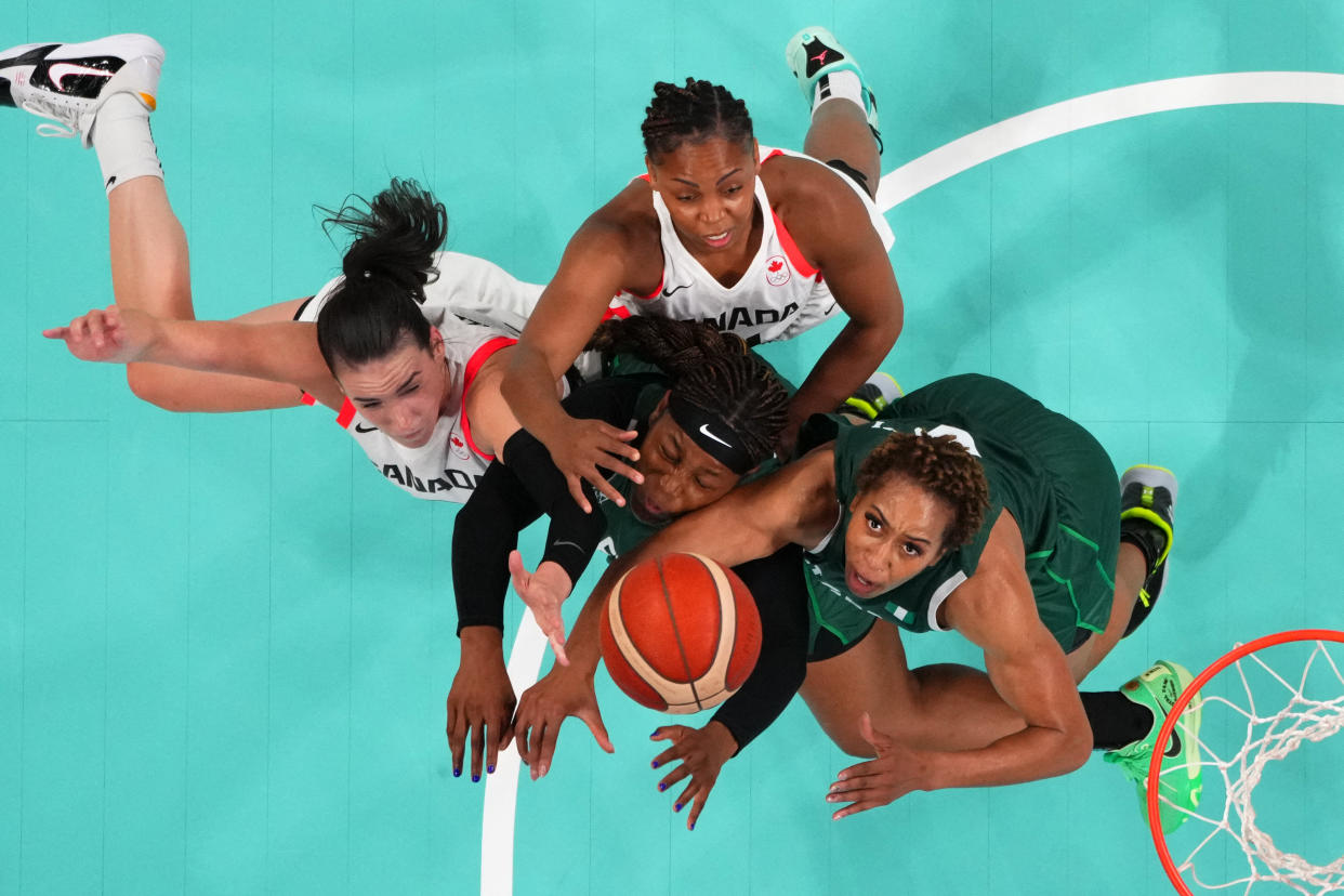 From left: Bridget Carleton and Nirra Fields, of Canada, and Amy Okonkwo and Pallas Kunaiyi-Akpanah, of Nigeria, go for a rebound in a basketball match between Canada and Nigeria at the Olympic Games in France on Sunday.