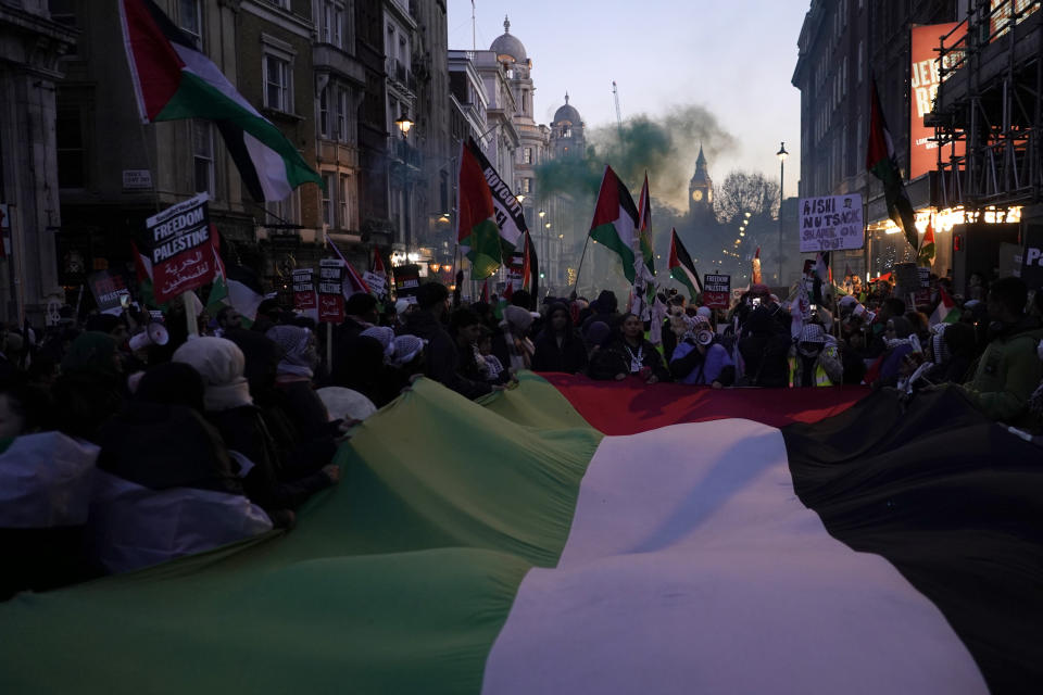 Protester hold flags and placards as they take part in a pro-Palestinian demonstration near Trafalgar Square in London, Saturday, Nov. 25, 2023. (AP Photo/Alberto Pezzali)