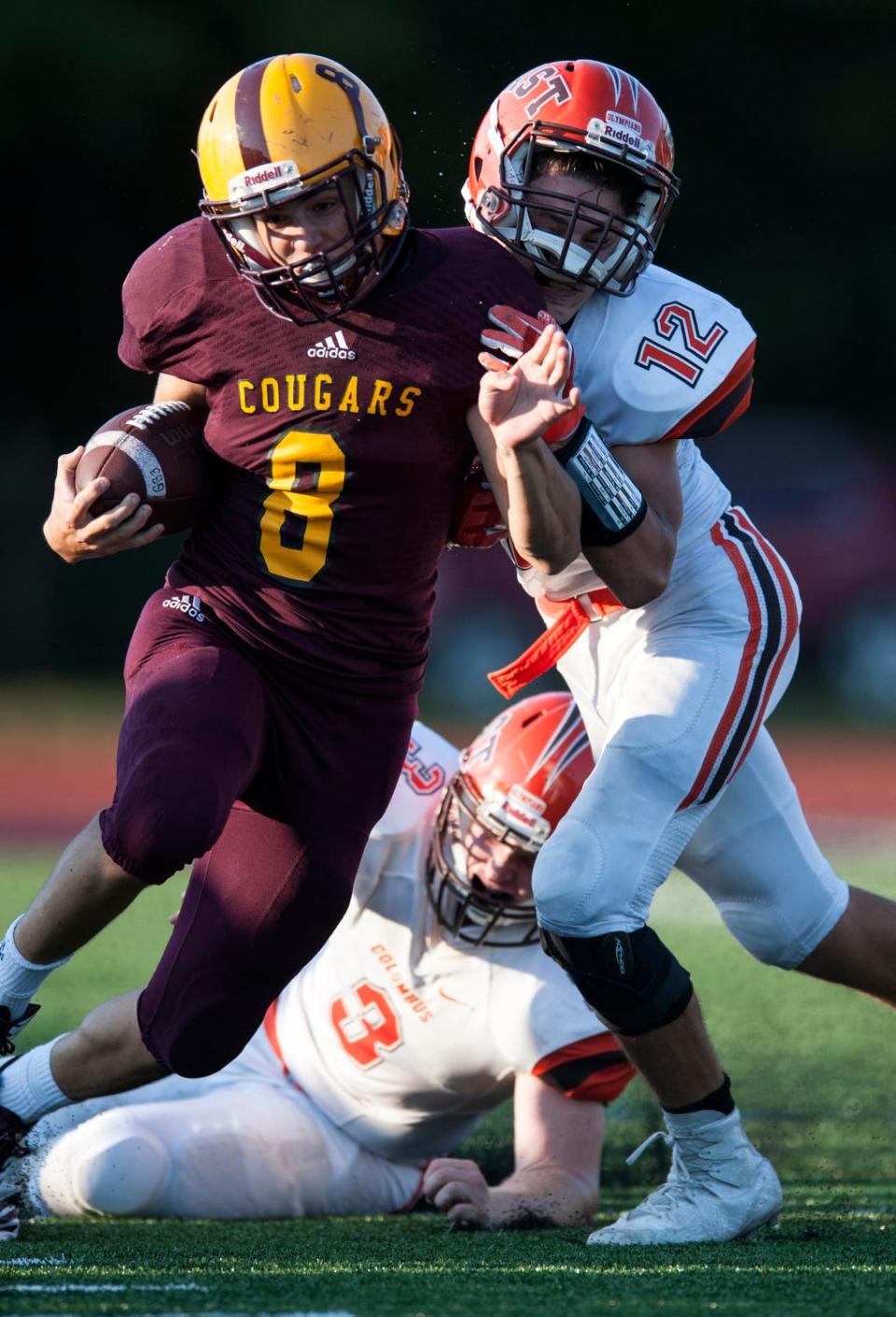 North running back Xavier Trueblood (8) takes a hit from Columbus East defensive back Jonah Wichman (12) during Bloomington North's 42-17 loss to Columbus East in August of 2017. Both schools are now in the same Class 5A sectional, along with Bloomington South and Seymour.