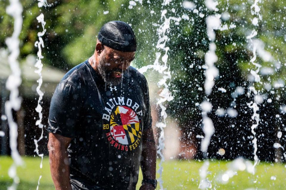 A man cools off in a fountain at Inner Harbor in Baltimore, Maryland.