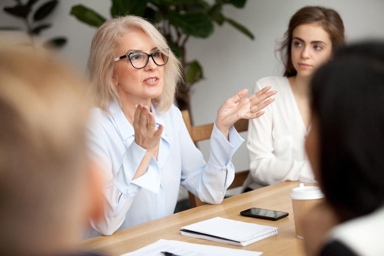 middle-aged business coach speaking to young people