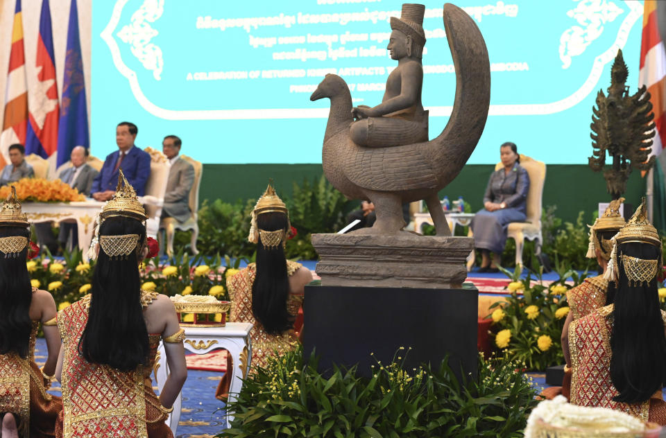 In this photo provided by Kok Ky/Cambodia's Government Cabinet, the 10th-century statue of Skanda atop a peacock, upper, is displayed during a handing over ceremony at Peace Palace, in Phnom Penh, Cambodia, Friday, March 17, 2023. Centuries-old cultural artifacts that had been illegally smuggled out from Cambodia were welcomed home Friday at a celebration led by Prime Minister Hun Sen, who offered thanks for their return and appealed for further efforts to retrieve such stolen treasures. (Kok Ky/Cambodia's Government Cabinet via AP)