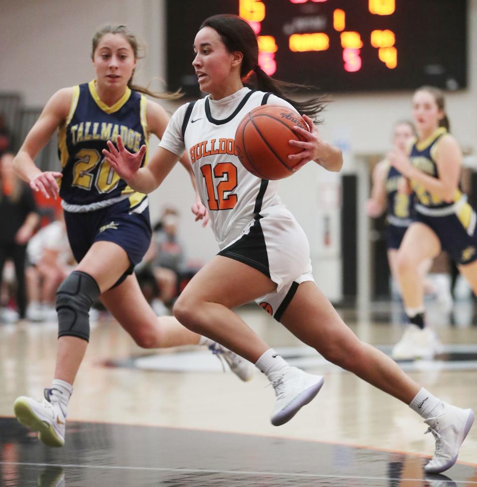 Green's Brianna Hunt drives to the basket as Tallmadge's Ashlyn Severns closes in during the first half Wednesday night at Green High School. Green won 72-28. [Mike Cardew/Beacon Journal]