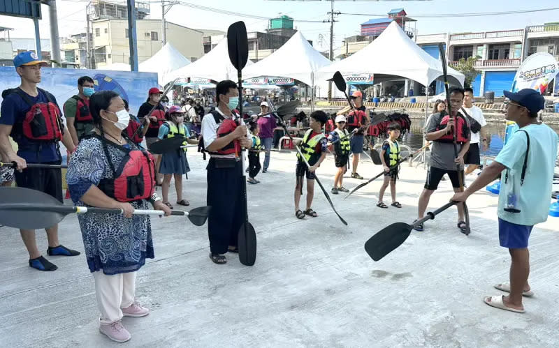 ▲高雄市政府海洋局舉辦水域遊憩體驗活動，教練宣導進行SUP立式划槳下水體驗前，民眾如何穿著救生衣及使用划槳等水域安全教學。(圖／高雄市政府海洋局提供)