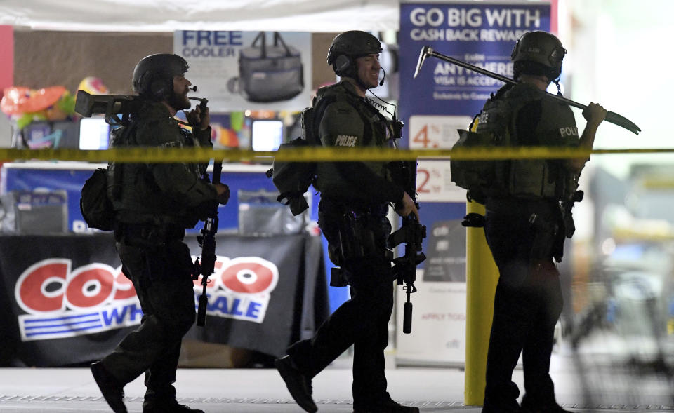 FILE - This June 14, 2019 file photo shows heavily armed police officers leaving the Corona, Calif., Costco store following a fatal shooting inside. A grand jury has declined to bring charges against an off-duty Los Angeles police officer who fatally shot Kenneth French during an altercation in the store. Riverside County District Attorney Mike Hestrin announced the grand jury's decision Wednesday, Sept. 25, 2019. (Will Lester/Inland Valley Daily Bulletin/SCNG via AP, File)