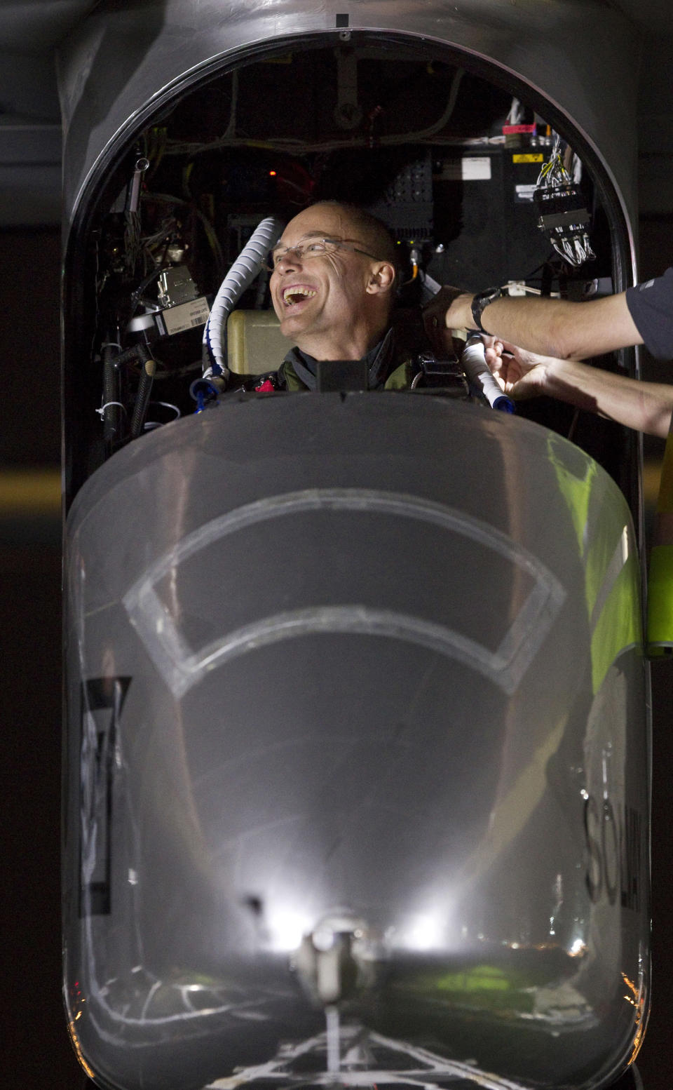 Pilot Bertrand Piccard is helped fit inside the experimental solar-powered airplane HB-SIA at Barajas airport in Madrid, Spain, Tuesday, June 5, 2012. The zero fuel airplane arrived in Madrid on May 25, 2012 from Payerne, Switzerland, and now goes on to Rabat, Morocco on its first transcontinental trip. The mission is described as the final dress rehearsal for a round-the-world flight with a new and improved aircraft in 2014. (AP Photo/Alberto Di Lolli)