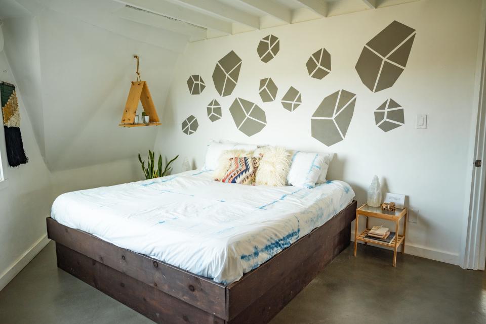 LArge white bed with geode-like design on wall behind it in Joshua tree dome