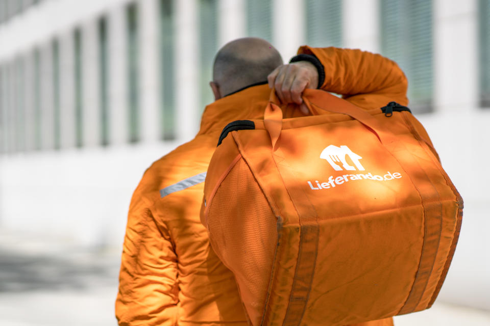 Berlin, Germany - May 9, 2020: Back turned Lieferando delivery man at work. Lieferando.de is one of the most popular ordering platforms on the Internet