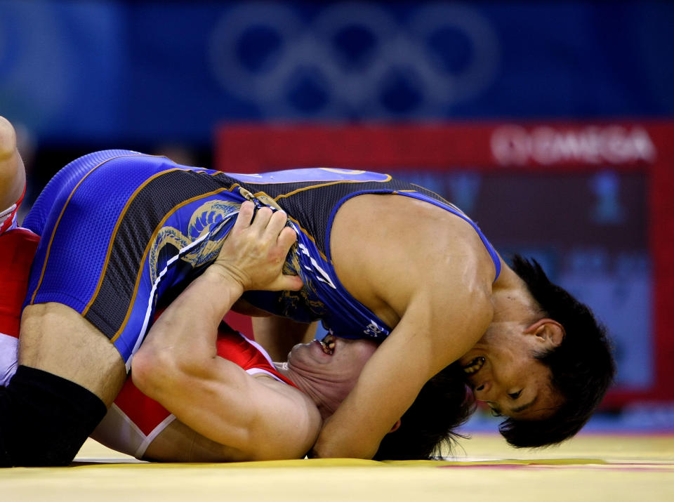 Kenichi Yumoto (blue) of Japan competes against Vitaly Koryakin (red) of Tajikistan in the 60 kg freestyle wrestling event at the China Agriculture University Gymnasium on Day 11 of the Beijing 2008 Olympic Games on August 19, 2008 in Beijing, China. (Jed Jacobsohn/Getty Images)