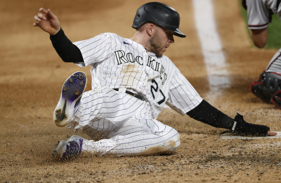 Colorado Rockies' Trevor Story scores on a double by Charlie Blackmon off Arizona Diamondbacks relief pitcher Kevin Ginkel during the eighth inning of a baseball game Tuesday, Aug. 11, 2020, in Denver. The Rockies won 8-7. (AP Photo/David Zalubowski)