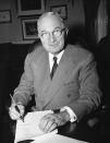 FILE - President Harry Truman in his White House office in Washington Dec. 16, 1950 signs a proclamation of a state of national emergency, summoning the nation to marshal its strength against the threat of "Communist world conquest." An emergency declared in 1950 by Truman to combat communism globally in the context of the Korean War was still in effect in the 1970s, before the law. (AP Photo/William J. Smith)