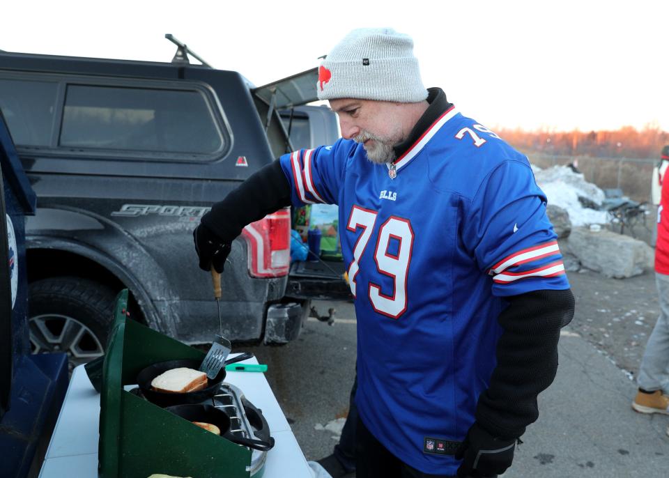 Steve Randall of Rochester makes grilled cheese and bacon sandwiches while tailgating before the Bills game against the Patriots.  