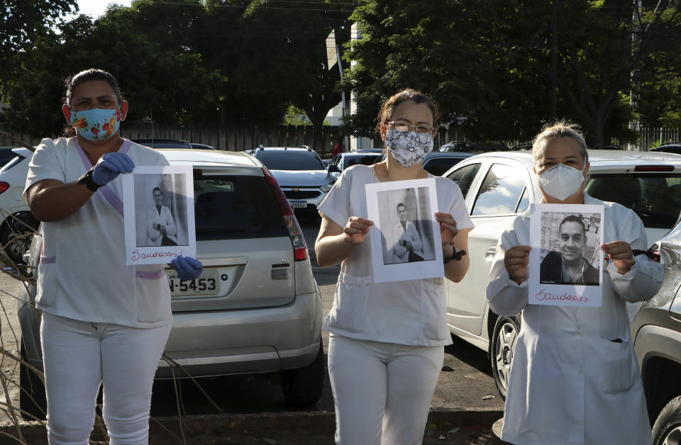 Health professionals hold up photos of people they say were their colleagues who died of COVID-19, as they protest outside "Pronto Socorro 28 de Agosto" Hospital, in Manaus, Brazil, Monday, April 27, 2020. Cases of the new coronavirus are overwhelming hospitals, morgues and cemeteries across Brazil as Latin America's largest nation veers closer to becoming one of the world's pandemic hot spots. (AP Photo/Edmar Barros)