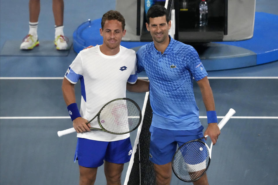 Roberto Carballes Baena, left, of Spain and Novak Djokovic of Serbia poise for a photo, ahead of their first round match at the Australian Open tennis championship in Melbourne, Australia, Tuesday, Jan. 17, 2023. (AP Photo/Aaron Favila)