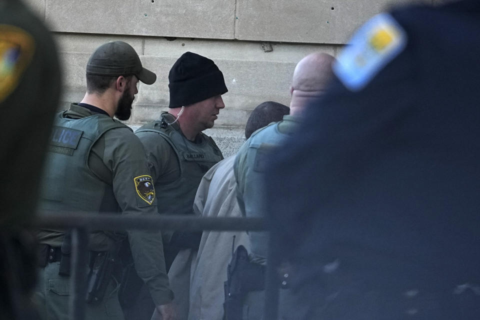 Officers escort Richard Matthew Allen into the Carroll County Courthouse, Tuesday, Nov. 22, 2022, in Delphi, Ind. An Indiana judge will hear if sealed court documents with evidence that led to a Allen's arrest in the 2017 slayings of two teenage girls will be publicly released. Allen, a 50-year-old of Delphi, Indiana, was charged last month with two counts of murder in the killings of Liberty German, 14, and Abigail Williams, 13. (AP Photo/Darron Cummings)