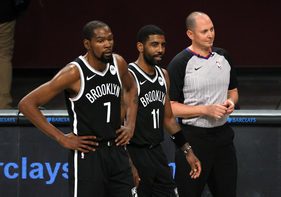 NEW YORK, NEW YORK - DECEMBER 13: Kevin Durant #7 and Kyrie Irving #11 of the Brooklyn Nets look on with the referee during the first half against the Washington Wizards at Barclays Center on December 13, 2020 in the Brooklyn borough of New York City. NOTE TO USER: User expressly acknowledges and agrees that, by downloading and or using this photograph, User is consenting to the terms and conditions of the Getty Images License Agreement. (Photo by Sarah Stier/Getty Images)