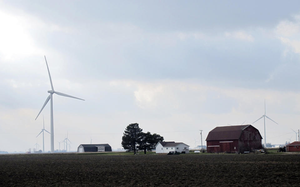 FILE - Wind turbines are scattered across farmland near Port Austin, Mich. Dec. 3, 2014. More than a dozen states have given themselves the power to override local zoning restrictions blocking large-scale renewable energy projects. The decisions come as some states implement ambitious goals requiring utility providers to generate 100% carbon-free energy by 2040. (AP Photo/John Flesher, File)