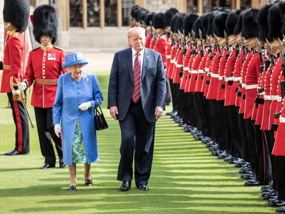 Donald Trump and Queen Elizabeth II inspect a guard of honour at Windsor Castle, in July 2018. He caused a brief breach of protocol by walking in front of her (Getty)