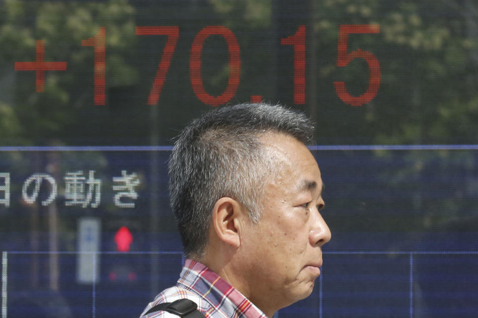 A man walks by an electronic stock board of a securities firm in Tokyo, Tuesday, Oct. 1, 2019. Shares rose in Asia on Tuesday, with markets in Hong Kong and Shanghai closed for a national day holiday. (AP Photo/Koji Sasahara)
