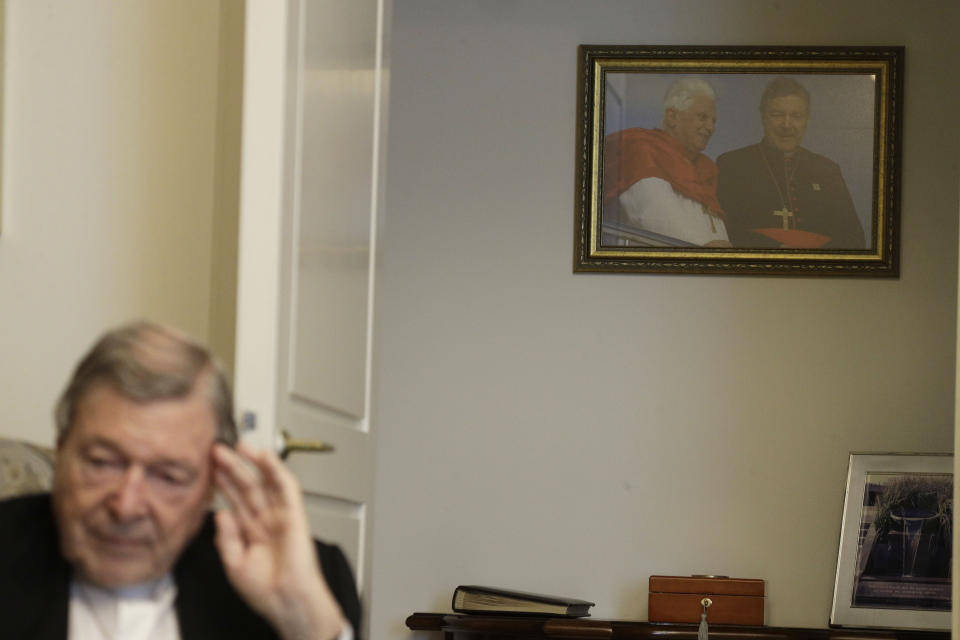 A picture of Pope Benedict XVI and Australian Cardinal George Pell taken in Sydney during the 2008 World Youth Day hangs on a wall of Cardinal Pell's home while he is interviewed by The Associated Press at the Vatican, Thursday, May 20, 2021. Pell, who was convicted and then acquitted of sex abuse charges in his native Australia, is spending his newfound freedom in Rome. (AP Photo/Gregorio Borgia)