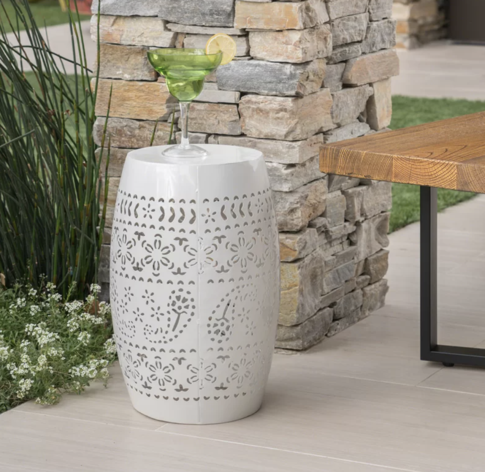 Bungalow Rose Ifrane Metal Side Table in white with green cocktail sitting on it (Photo via Wayfair)