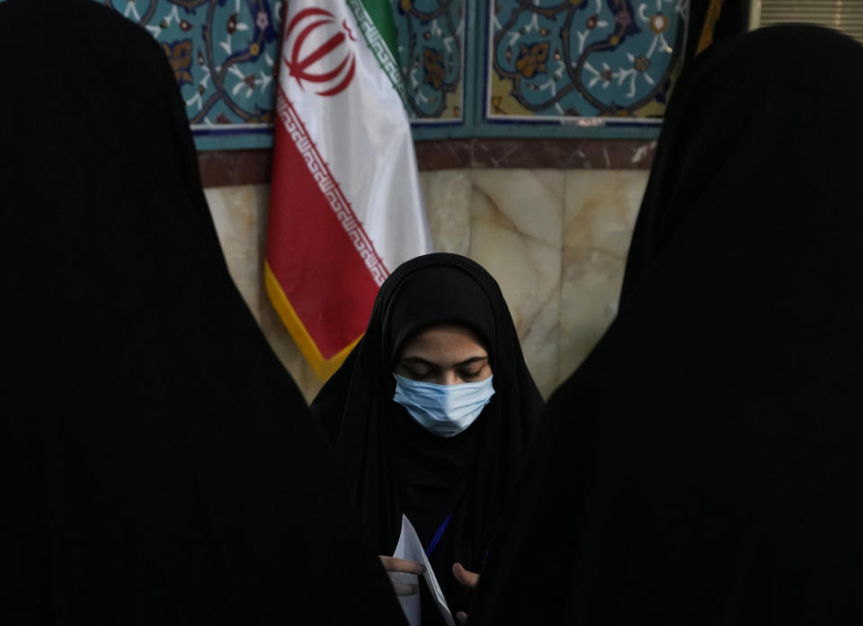 A staff member of a polling station prepares ballot papers for voters during the parliamentary and Assembly of Experts elections at a polling station in Tehran, Iran, Friday, March 1, 2024. Iran began voting Friday in its first elections since the mass 2022 protests over its mandatory hijab laws after the death of Mahsa Amini, with questions looming over just how many people will turn out for the poll. (AP Photo/Vahid Salemi)