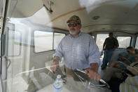 Harold Osborn, great-great-grandson of the McIlhenny Co.'s founder, pilots a boat as he tours the wetlands with employees and The Associated Press, on Avery Island, La., where Tabasco brand pepper sauce is made, Tuesday, April 27, 2021. As storms grow more violent and Louisiana loses more of its coast, the family that makes Tabasco Sauce is fighting erosion in the marshland that buffers it from hurricanes and floods. Overall, it’s probably a standoff, says CEO and president Osborn. (AP Photo/Gerald Herbert)