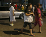 <p>Hotel guests, one with a robe wrapped around her body, walk away from the Resorts World Manila complex early Friday, June 2, 2017 in suburban Pasay city southeast of Manila, Philippines. (Photo: Bullit Marquez/AP) </p>