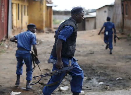 Policeman run during a protest against Burundi President Pierre Nkurunziza and his bid for a third term in Bujumbura, Burundi, May 26, 2015. REUTERS/Goran Tomasevic