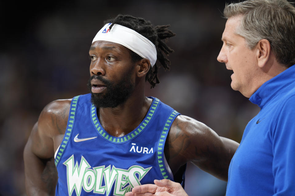 Minnesota Timberwolves guard Patrick Beverley, left, confers with head coach Chris Finch in the second half of an NBA basketball game against the Denver Nuggets, Friday, April 1, 2022, in Denver. (AP Photo/David Zalubowski)