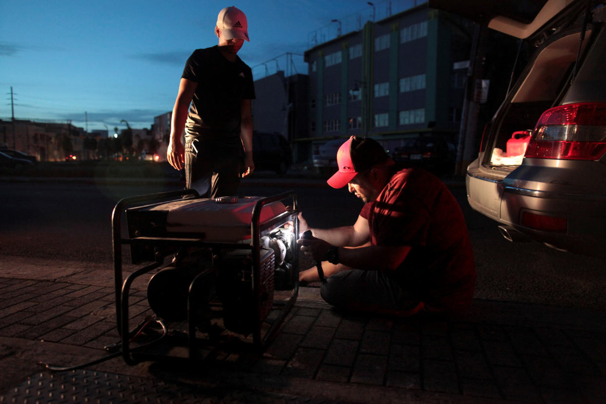 A man tries to repair a generator in San Juan, Puerto Rico