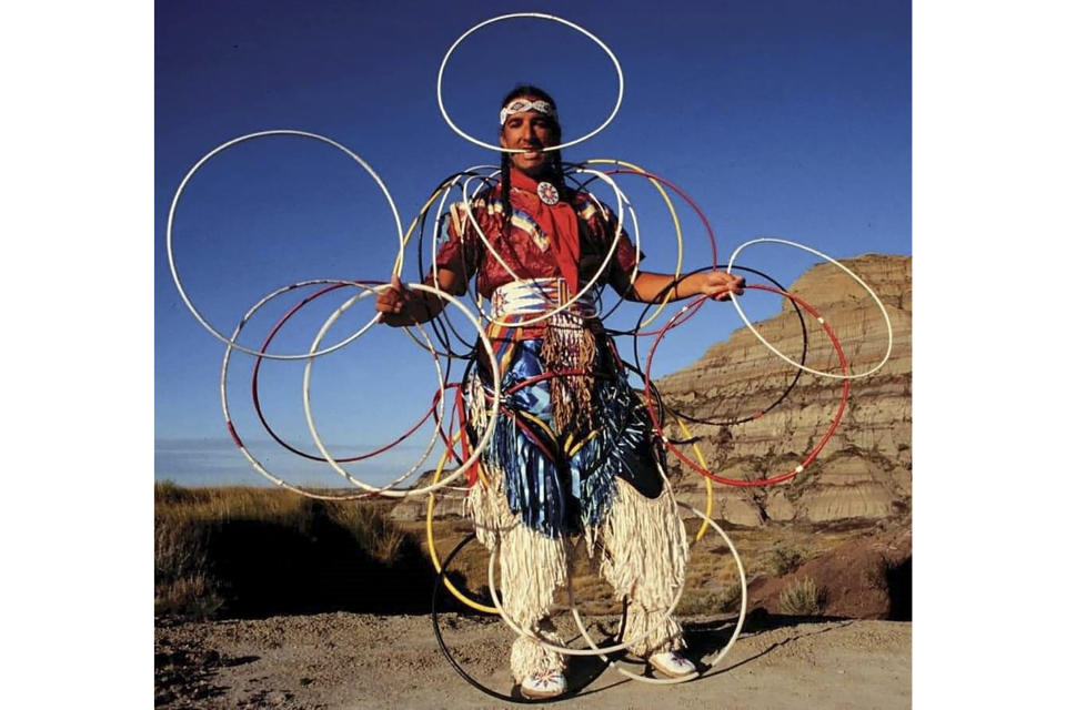 This photo provided by Ohiyesa Locke shows Kevin Locke, performing in the Badlands, S.D., in 2002. An acclaimed Native American flute player, hoop dancer, cultural ambassador and educator, Locke died in South Dakota at age 68 on Friday, Sept. 30, 2022, according to his family. (Ohiyesa Locke via AP)