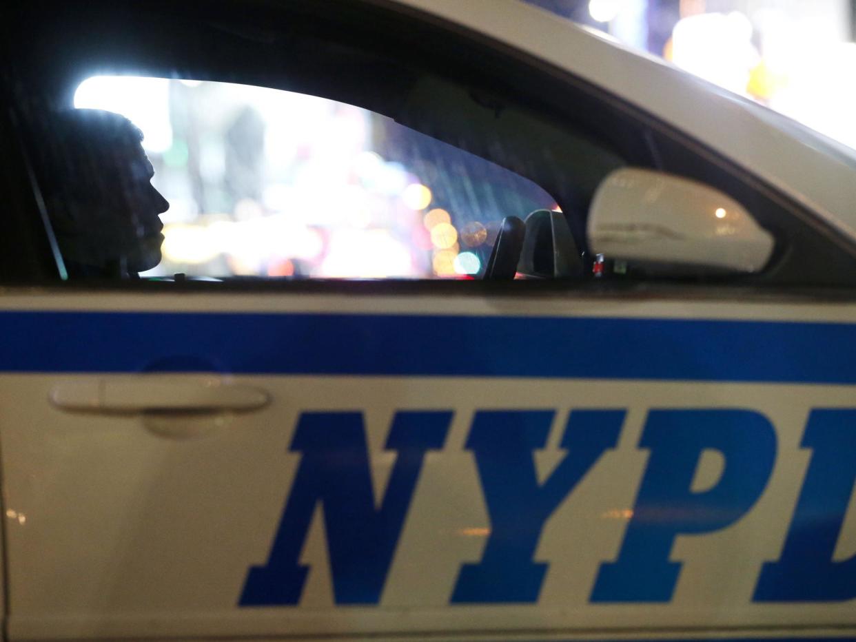 A New York City police officer sits in a cruiser at a checkpoint surrounding Times Square: (2020 The Associated Press)