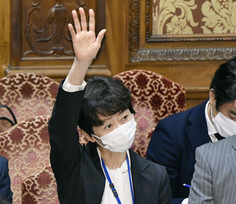 FILE - In this Thursday, Feb. 25, 2021, file photo, Makiko Yamada, public affairs official of Japanese Prime Minister Yoshihide Suga's cabinet, raises her hand during a parliamentary session at the lower house in Tokyo. Yamada has resigned Monday, March 1, 2021 after she acknowledged she had a 70,000 yen ($700) dinner paid for by a broadcaster. The broadcaster in question employs Suga’s son, Seigo Suga.(Yoshitaka Sugawara/Kyodo News via AP, File)