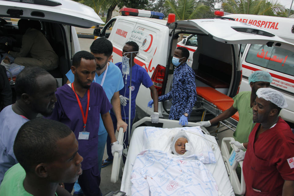Medical personnel carry a wounded child to be airlifted to the Turkish capital for treatment after they were injured in Saturday's car bomb blast in Mogadishu, Somalia, Sunday, Dec. 29, 2019. A truck bomb exploded at a busy security checkpoint in Somalia's capital Saturday morning, killing at least 79 people including many students, authorities said. It was the worst attack in Mogadishu since the devastating 2017 bombing that killed hundreds. (AP Photo/Farah Abdi Warsameh)