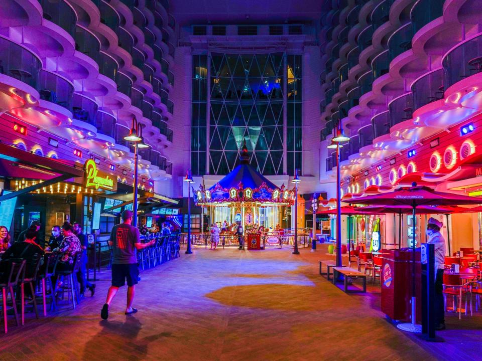 Deck 6 of the world's largest cruise ship, a boardwalk with a carousel in the middle, lit up at night