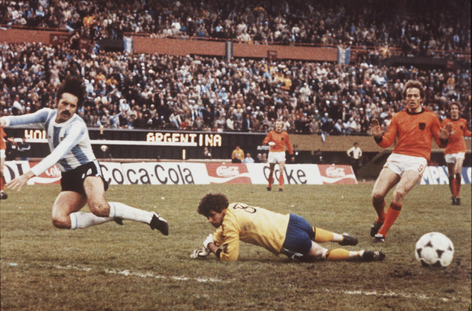 FILE - Argentinian Leopoldo Luque, left, flies through the air as Dutch goalkeeper Jan Jongbloed, center, foils his attack during the World Cup Final at the River Plate Stadium, Buenos Aires on June 25, 1978. Jongbloed, who was runner-up in two World Cup finals as part of the "Clockwork Orange" Netherlands soccer teams in the 1970s, has died at age 82, soccer authorities said Thursday Aug. 31, 2023. Jongbloed and the Netherlands lost both finals, 2-1 to West Germany in 1974 and 3-1 to host nation Argentina after extra time four years later. (AP Photo/Heinz Ducklau, File)