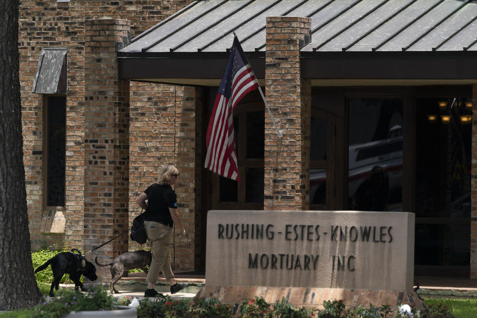 A woman with two comfort dogs enters a mortuary during a visitation for Maite Yuleana Rodriguez, one of the victims killed in last week's elementary school shooting in Uvalde, Texas, Monday, May 30, 2022. (AP Photo/Jae C. Hong)