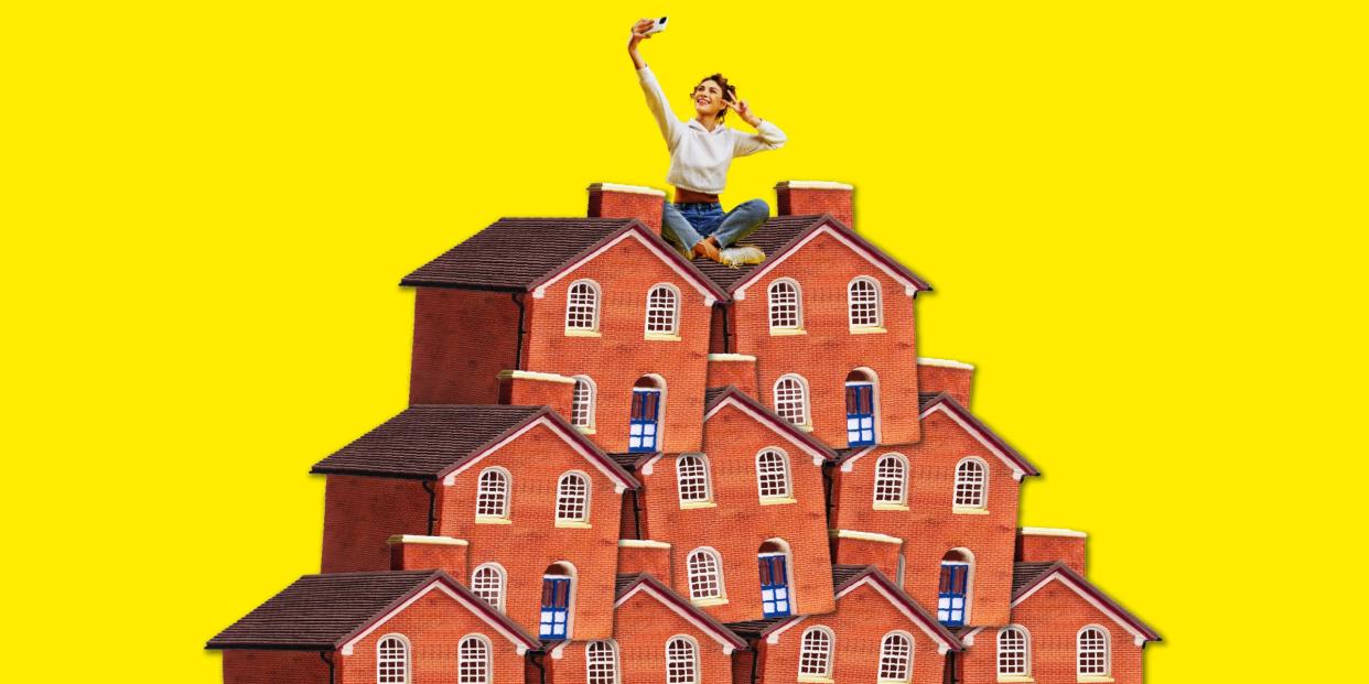 woman taking a selfie while sitting cross legged on a pile of houses