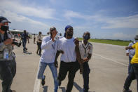 Police detain a Haitian who was deported from the United States, after he tried to board the same plane in which he was deported in, in an attempt to return to the United States, at the Toussaint Louverture airport in Port-au-Prince, Haiti Tuesday, Sept. 21, 2021 (AP Photo/Joseph Odelyn)