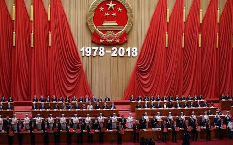 People who received awards for contributing to China's development hold their certificates during a celebration meeting marking the 40th anniversary of China's "reform and opening up" policy - Credit:  WANG ZHAO/ AFP