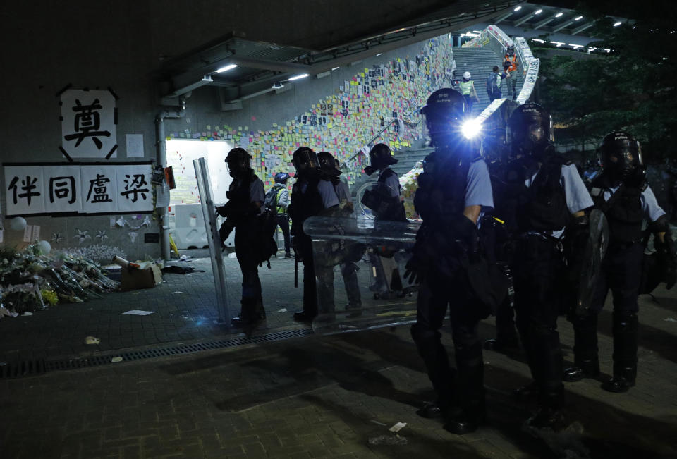 Police officers in anti-riot gear clear protesters from the Legislative Council in Hong Kong, during the early hours of Tuesday, July 2, 2019. Hundreds of protesters in Hong Kong swarmed into the legislature's main building Monday night, tearing down portraits of legislative leaders and spray-painting pro-democracy slogans on the walls of the main chamber as frustration over a lack of response from the administration to opposition demands boiled over. (AP Photo/Vincent Yu)