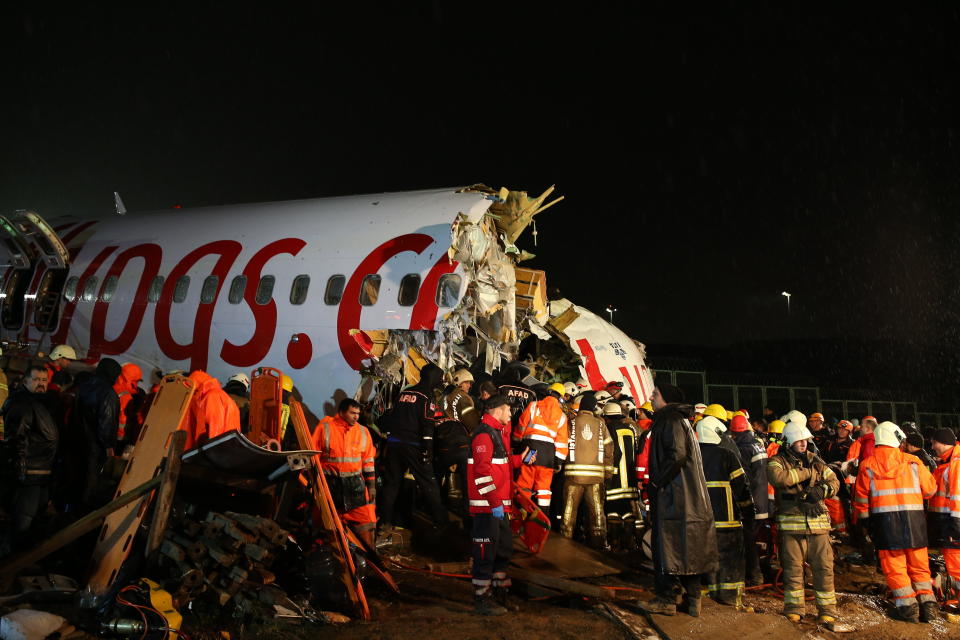 Rescatistas y bomberos trabajan alrededor de los restos de un avión luego de que se salió de la pista del aeropuerto Sabiha Gokcen, en Estambul, el miércoles 5 de febrero de 2020. (AP Foto/Emrah Gurel)