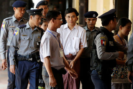 Detained Reuters journalist Kyaw Soe Oo is escorted by police before a court hearing in Yangon, Myanmar April 20, 2018. REUTERS/Ann Wang