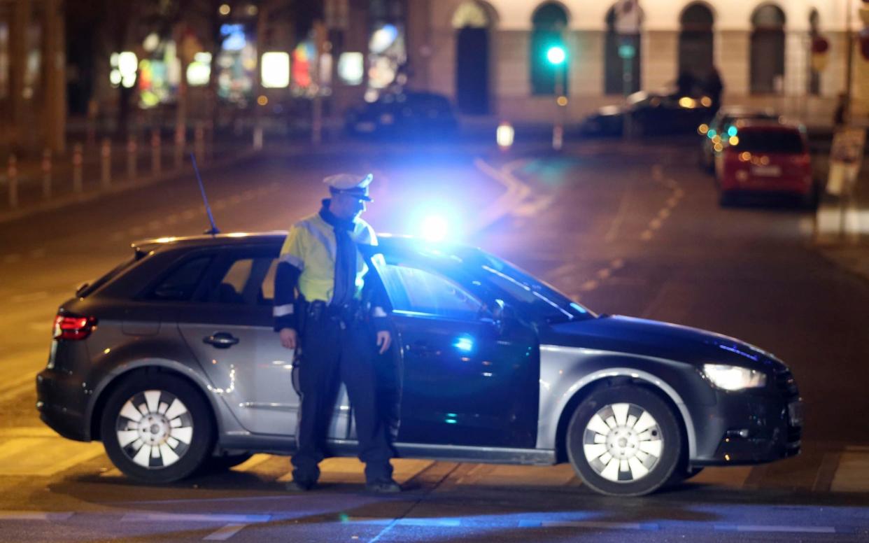 An officer blocks a street while police search for a knife attacker - AP