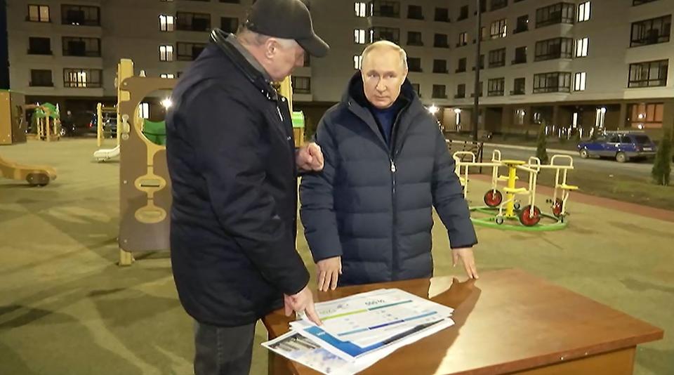 Russian President Vladimir Putin (R) listens to Russian Deputy Prime Minister Marat Khusnullin at a newly built neighborhood in Mariupol in Russian-controlled Donetsk region on March 19, 2023.